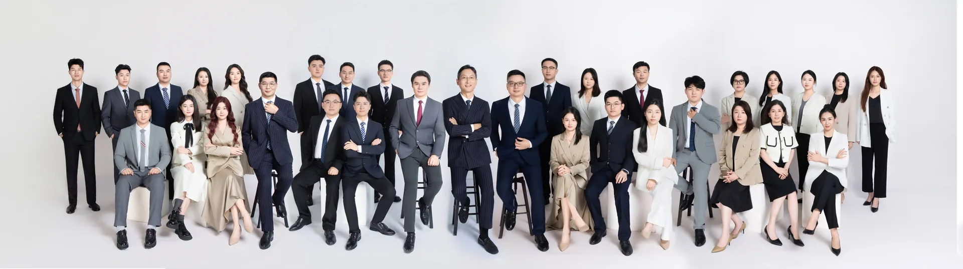 Studio group photo of the whole Unibest team: colleagues in business attire, arranged in four neat rows against a white backdrop
